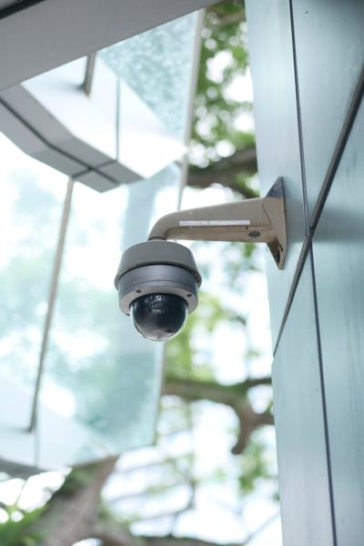 A high-tech surveillance camera installed on a modern architecture outdoor wall.